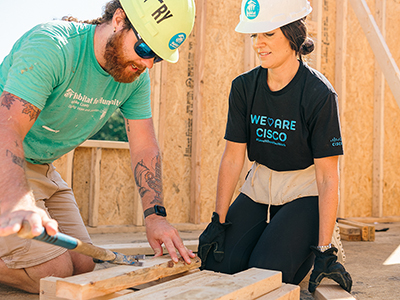 Image of two Cisco employees working on a house