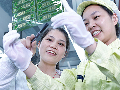 Image of two women workers looking at a circuit board